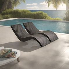 two lounge chairs sitting next to a swimming pool