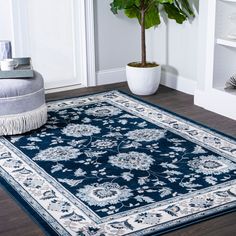 a blue area rug with an ornate design on the bottom and fringe trim around the edges