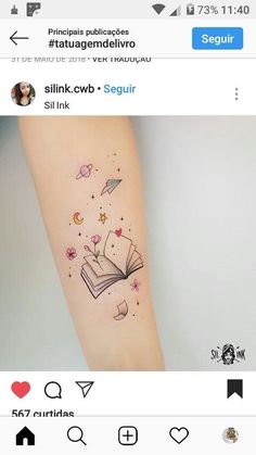 an open book tattoo on the right arm with stars and hearts coming out of it