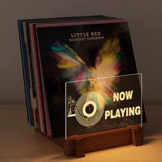 a stack of cd's sitting on top of a wooden stand next to each other