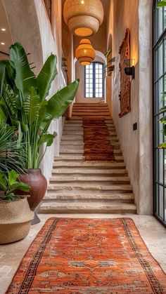 a large rug is on the floor in front of some stairs and potted plants