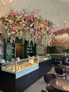 a restaurant with flowers hanging from the ceiling