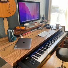 a desk with a keyboard, laptop and computer monitor