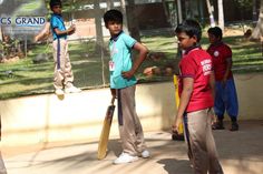 several young boys are standing in front of a fence with their bats and ball equipment