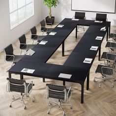 an empty conference room with black tables and chairs