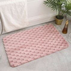 a pink bath mat sitting on top of a bathroom floor