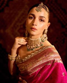 a woman in a red sari and gold jewelry