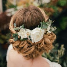 a woman with flowers in her hair is wearing a flower crown on top of her head