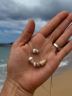 ✨ Mexico X Kauai" Collection ✨ * Hand-picked cone shells off the shores of Kauai, Hawaii turned into pretty shell necklaces. One of a kind Kauai cone shell floating necklaces of your choice. A single cone shell choker or a mid-length floating trio. If you would like a specific length please reach out for customizations. ♥ Hand picked Kauai cone shells ♥ 14k gold fill snake chain ♥ Single cone shell choker approx. 14.5" + 2" extender for a total length of 16.5" in length ♥ Trio cone shell necklac Random Necklaces, Unique Gold Shell Necklaces, Gold Shell Necklace In Ocean-inspired Style, Hawaiian Shell Necklaces, Beachy Shell-shaped Shell Jewelry, Gold Handmade Shell-shaped Necklace, Unique Shell-shaped Shell Necklaces, Shell Accessories, Cone Shell