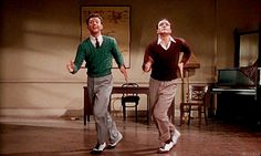 two men in sweaters are dancing on the floor