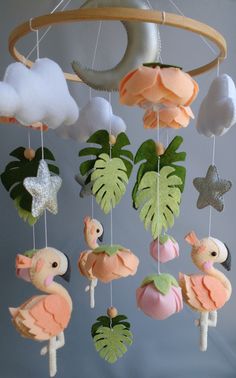 a mobile with flamingos, palm leaves and stars hanging from it