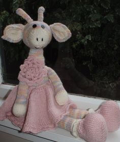 a knitted giraffe sitting on top of a window sill