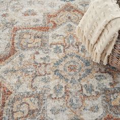 an area rug is laying on the floor next to a wicker basket