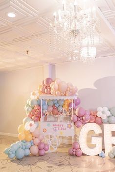 an ice cream cart is decorated with balloons and lights for a g5 birthday party