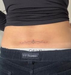 a woman's stomach with a small tattoo on her lower back and the words,