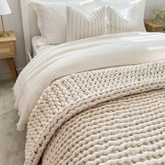 a bed with white blankets and pillows on top of it