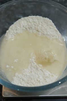 a glass bowl filled with flour on top of a stove