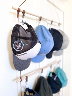 several hats hanging from hooks on a wall