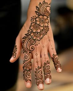 a woman's hand with henna tattoos on it