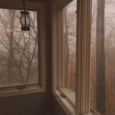 a window with the view of trees outside and fog in the air from inside it