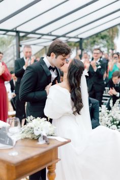 a bride and groom kissing in front of an audience