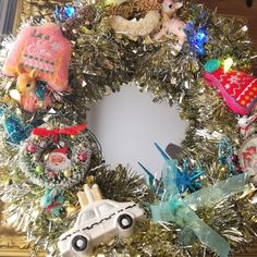 a christmas wreath with ornaments on it and a car ornament hanging from the front