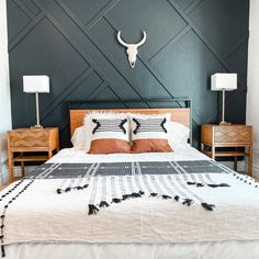 a bed with two nightstands and a cow skull on the wall