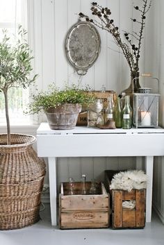 a white table with baskets and plants on it