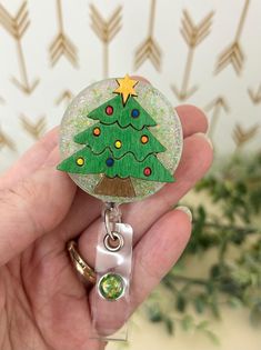 Christmas Tree Badge Reels, RN Graduation Gift, Christmas, Christmas tree, Teacher badge, Christmas tree Badge reel, Durable & Retractable, or Detachable Check out our new badge reels! We are adding new products to our shop. This cute little Christmas tree badge reels work great for anyone having to use name badges. It has green glitter and resin on the back that makes the tree sparkle. The tree is made of wood and is hand painted and fastened on with resin This topper measures 1.5 inches x 1.5 inches! It has an alligator clip for attaching to garment and is permanently attached.  **If you would like a detachable one made with Velcro instead please list in the note to seller. I would be happy to accommodate.** While all badge reels are made to match pictures as shown in listing, please not Christmas Badge Reels Diy, Customizable Themed Badge Reel For Gift, Customizable Red Badge Reel As A Gift, Holiday Badge Reel, Black Retractable Badge Reel For Gift, Little Christmas Tree, Resin Christmas