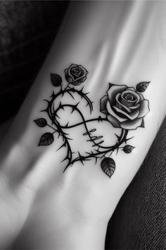 a black and white photo of a rose tattoo on the side of a woman's foot