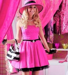 a woman in a pink dress and hat posing for the camera with her handbag