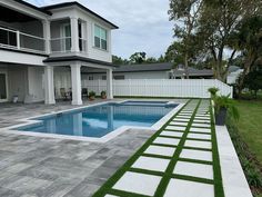 a large backyard with a swimming pool and grass on the ground in front of it