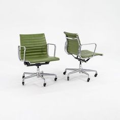 two office chairs sitting next to each other on casteors, one green and the other black