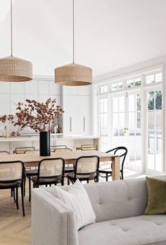 a living room filled with furniture next to a dining room table and chairs on top of a hard wood floor