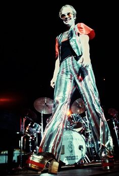 a woman in silver pants and sunglasses on stage