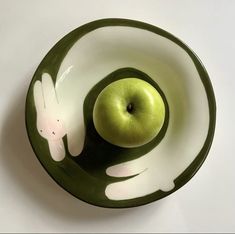 a bowl with an apple in the shape of a bunny and a rabbit on it