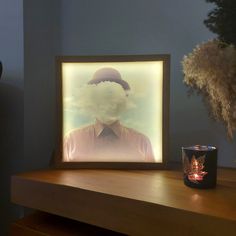 a candle is sitting on a table next to a photo