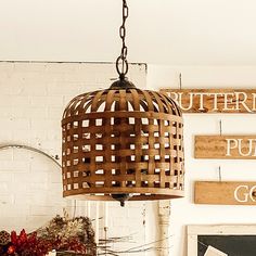 a wooden light hanging from a ceiling in a room with signs on the wall behind it