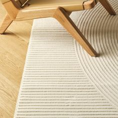 a wooden chair sitting on top of a white rug