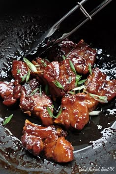 some meat is being cooked in a frying pan