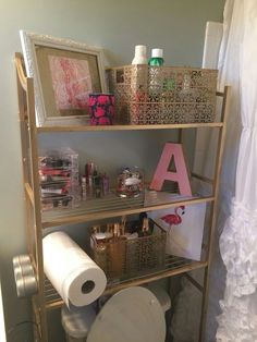 a bathroom shelf with toilet paper and other items on it