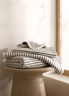 stack of folded towels sitting on top of a pedestal