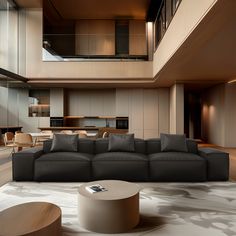 a living room filled with furniture and a large window next to a stair case on the wall