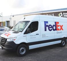 a white fed ex truck parked in front of a building