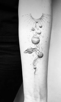 a woman's arm with planets on it and the sun in the sky above