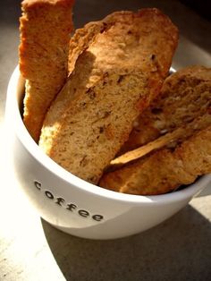 a white bowl filled with sliced bread on top of a table