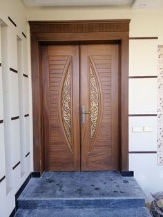 two wooden doors with decorative designs on the front and side panels in an entry way