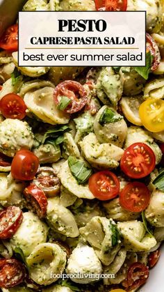 pesto caprese pasta salad with tomatoes and mozzarella in a white bowl