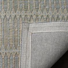 an up close view of the back end of a gray and beige couch with a pattern on it