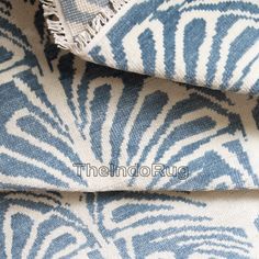 two blue and white towels folded on top of each other with fringes in the middle